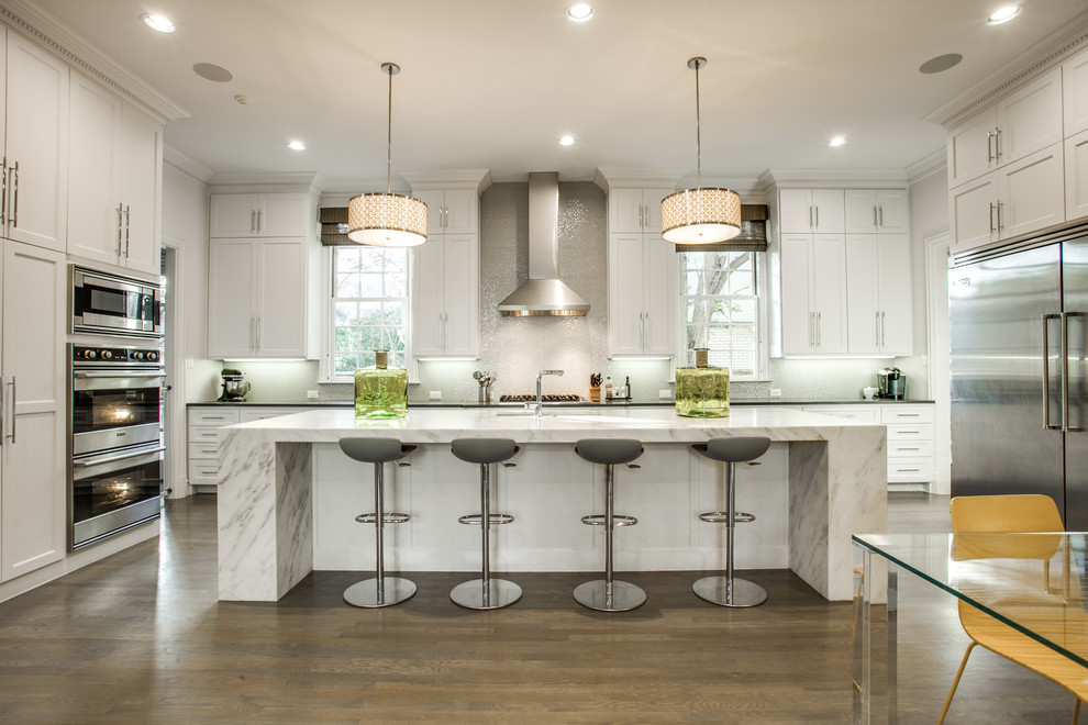 Inspiration for a transitional dark wood floor eat-in kitchen remodel in Dallas with an undermount sink, shaker cabinets, white cabinets, gray backsplash, stainless steel appliances and an island