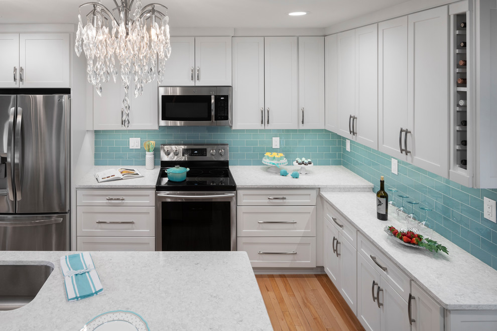 Exempel på ett mellanstort klassiskt vit vitt kök, med luckor med infälld panel, vita skåp, bänkskiva i kvarts, blått stänkskydd, stänkskydd i glaskakel och en köksö