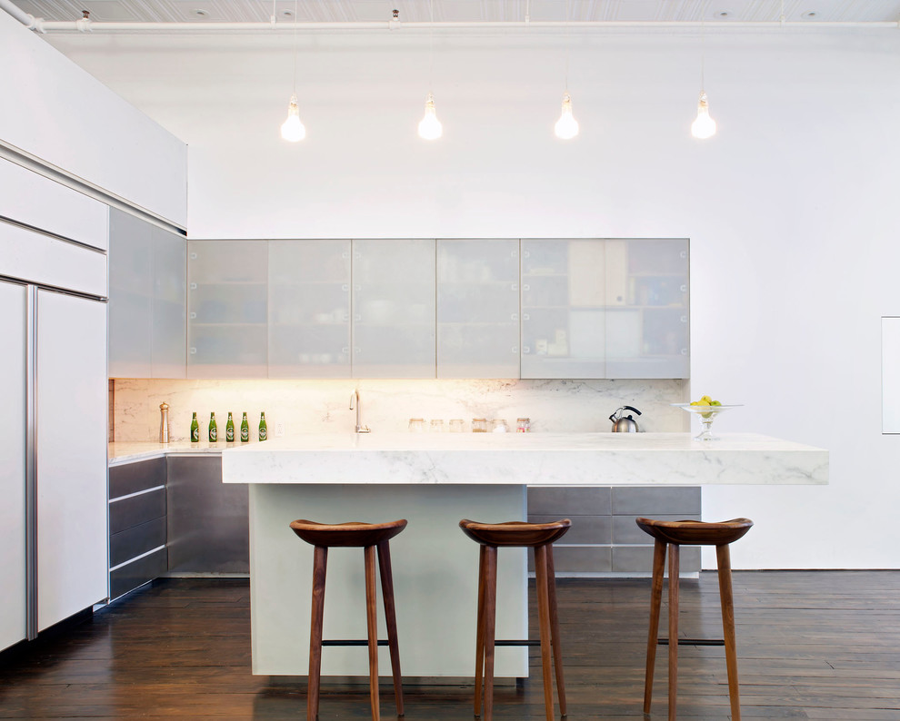 Exempel på ett modernt l-kök, med släta luckor, vita vitvaror, marmorbänkskiva, skåp i rostfritt stål, vitt stänkskydd och stänkskydd i marmor