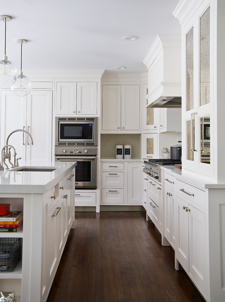 Exempel på ett mellanstort klassiskt l-kök, med en rustik diskho, vita skåp, bänkskiva i kvarts, grått stänkskydd, stänkskydd i keramik, integrerade vitvaror, mörkt trägolv, en köksö och luckor med infälld panel