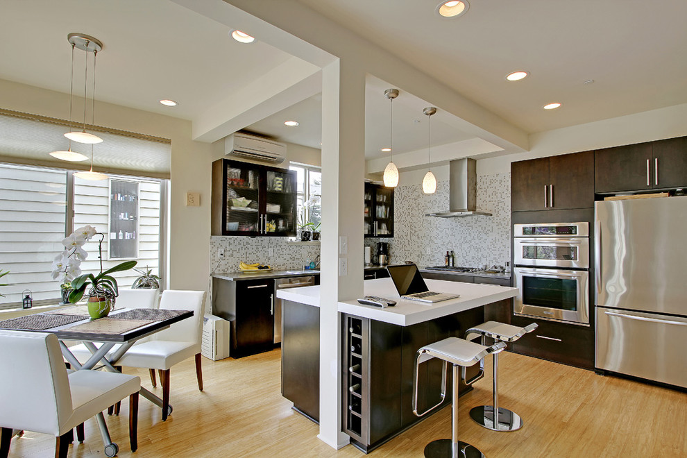 Example of a trendy kitchen design in Seattle with mosaic tile backsplash and stainless steel appliances