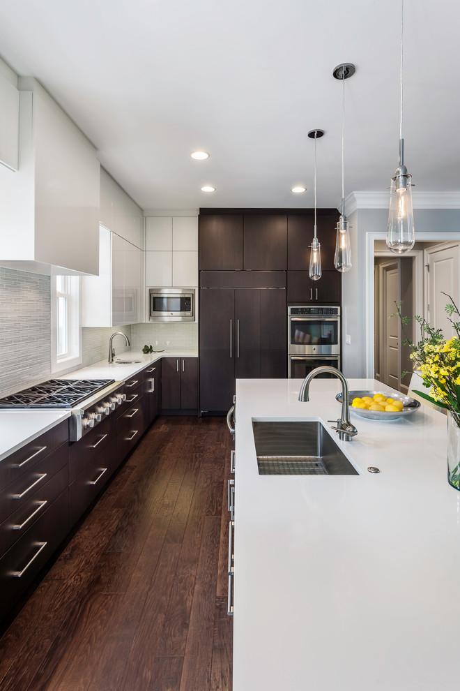 Inspiration for a contemporary l-shaped dark wood floor and brown floor open concept kitchen remodel in Other with an undermount sink, flat-panel cabinets, white cabinets, quartz countertops, white backsplash, ceramic backsplash, stainless steel appliances and an island