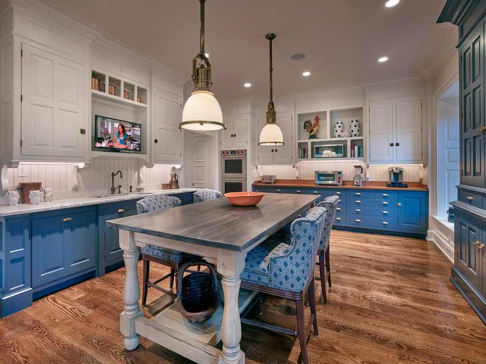 Idéer för att renovera ett stort lantligt linjärt kök, med luckor med upphöjd panel, blå skåp, vitt stänkskydd, mörkt trägolv, en köksö och brunt golv