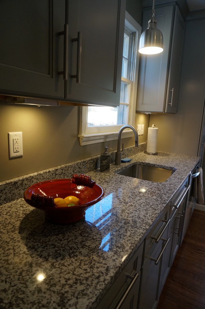 Klassische Küche mit Schrankfronten im Shaker-Stil, grauen Schränken, Granit-Arbeitsplatte, Küchenrückwand in Grau, Küchengeräten aus Edelstahl und braunem Holzboden in Sonstige