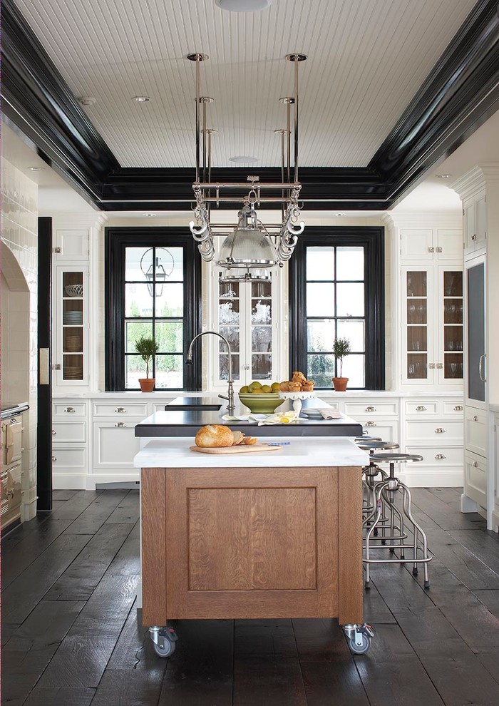 Inspiration for a large traditional u-shaped enclosed kitchen in New York with recessed-panel cabinets, white cabinets, dark hardwood flooring and an island.