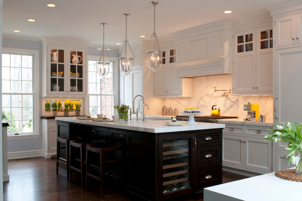 Example of a classic galley kitchen design in New York with recessed-panel cabinets, white cabinets, white backsplash, stone slab backsplash and paneled appliances
