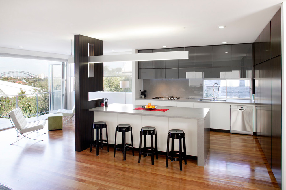 Moderne Küche in L-Form mit Unterbauwaschbecken, Glasfronten, Quarzwerkstein-Arbeitsplatte, Rückwand aus Stein und Küchenrückwand in Grau in Sydney