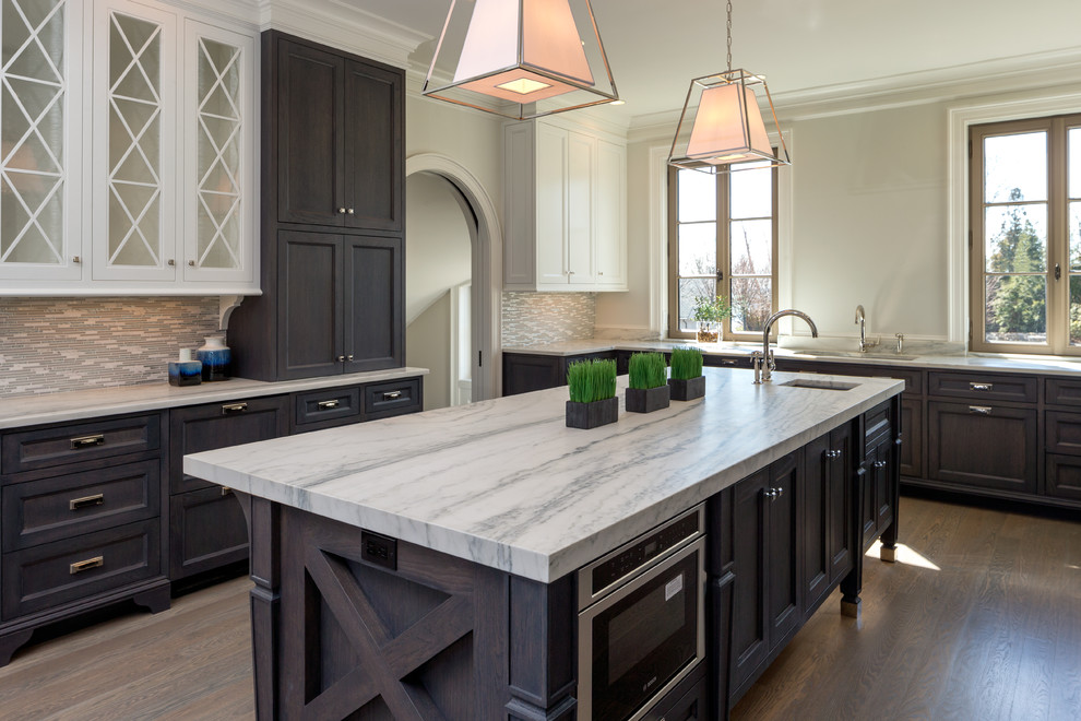 Exempel på ett stort klassiskt kök och matrum, med en undermonterad diskho, vita skåp, marmorbänkskiva, flerfärgad stänkskydd, stänkskydd i glaskakel, rostfria vitvaror, mellanmörkt trägolv och en köksö