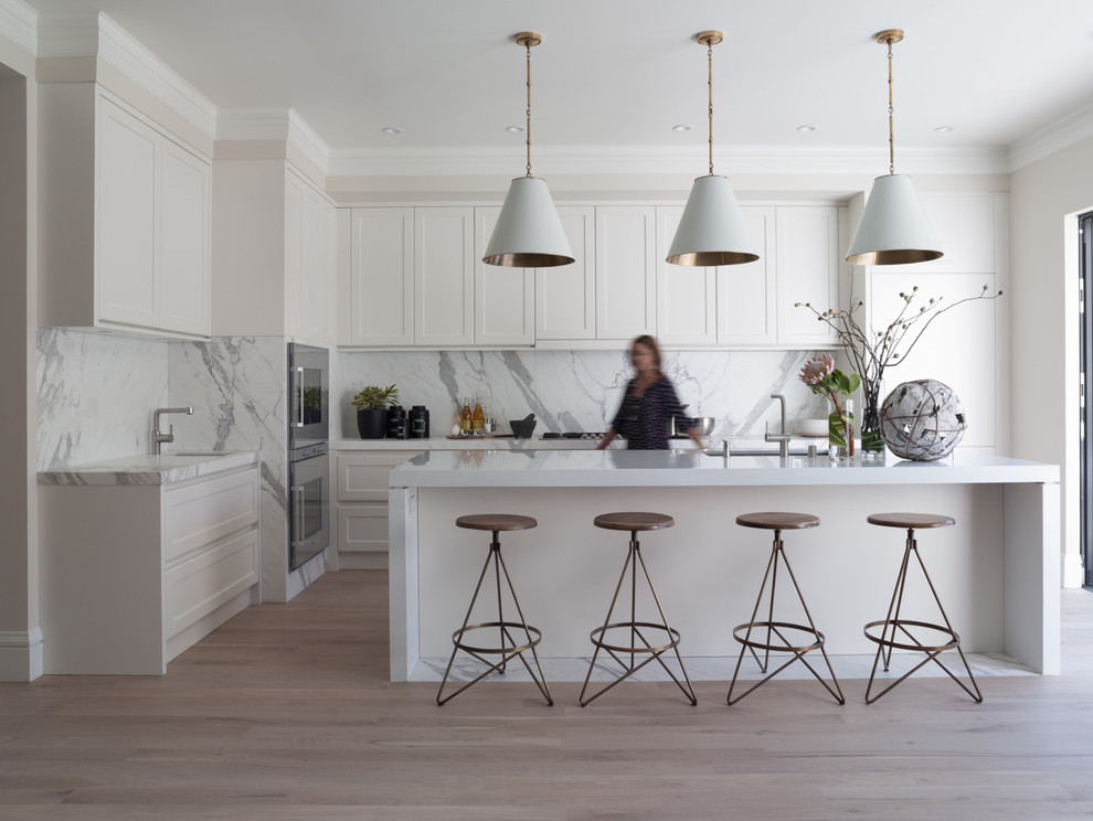 Moderne Küche in L-Form mit Unterbauwaschbecken, Schrankfronten im Shaker-Stil, weißen Schränken, Küchengeräten aus Edelstahl und Rückwand aus Marmor in San Francisco