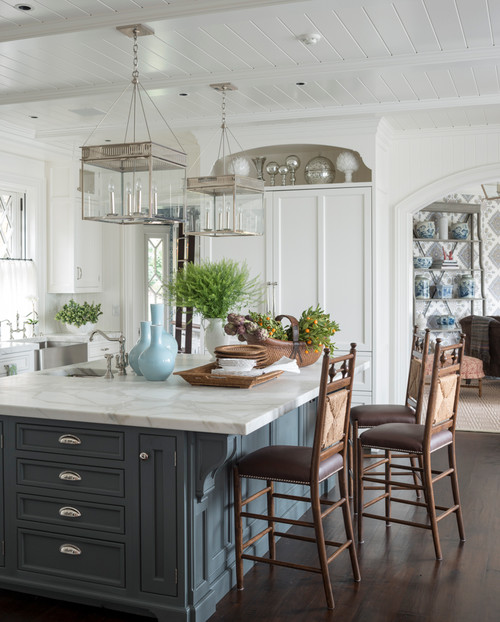 large classic u-shaped dark wood floor and brown floor kitchen design in Other with a farmhouse sink, recessed-panel cabinets, white cabinets, marble countertops, white backsplash, paneled appliances and an island 