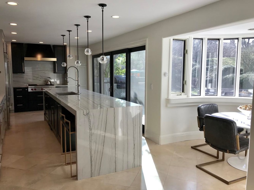 Eat-in kitchen - large transitional l-shaped limestone floor and beige floor eat-in kitchen idea in Denver with an undermount sink, shaker cabinets, black cabinets, marble countertops, white backsplash, marble backsplash, black appliances, an island and white countertops