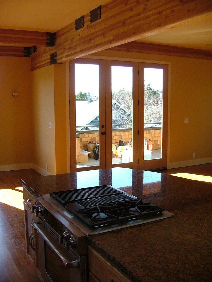 Offene, Mittelgroße Moderne Küche mit Granit-Arbeitsplatte, Küchengeräten aus Edelstahl, braunem Holzboden und Kücheninsel in Seattle