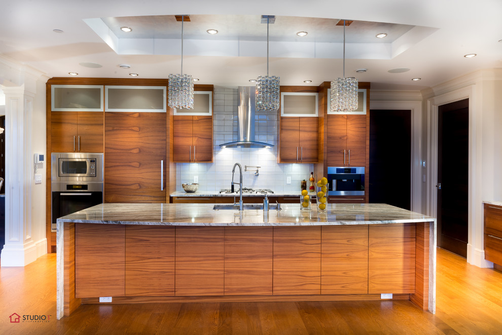 Inspiration for a large contemporary single-wall medium tone wood floor eat-in kitchen remodel in Vancouver with an undermount sink, flat-panel cabinets, medium tone wood cabinets, granite countertops, white backsplash, glass tile backsplash and stainless steel appliances