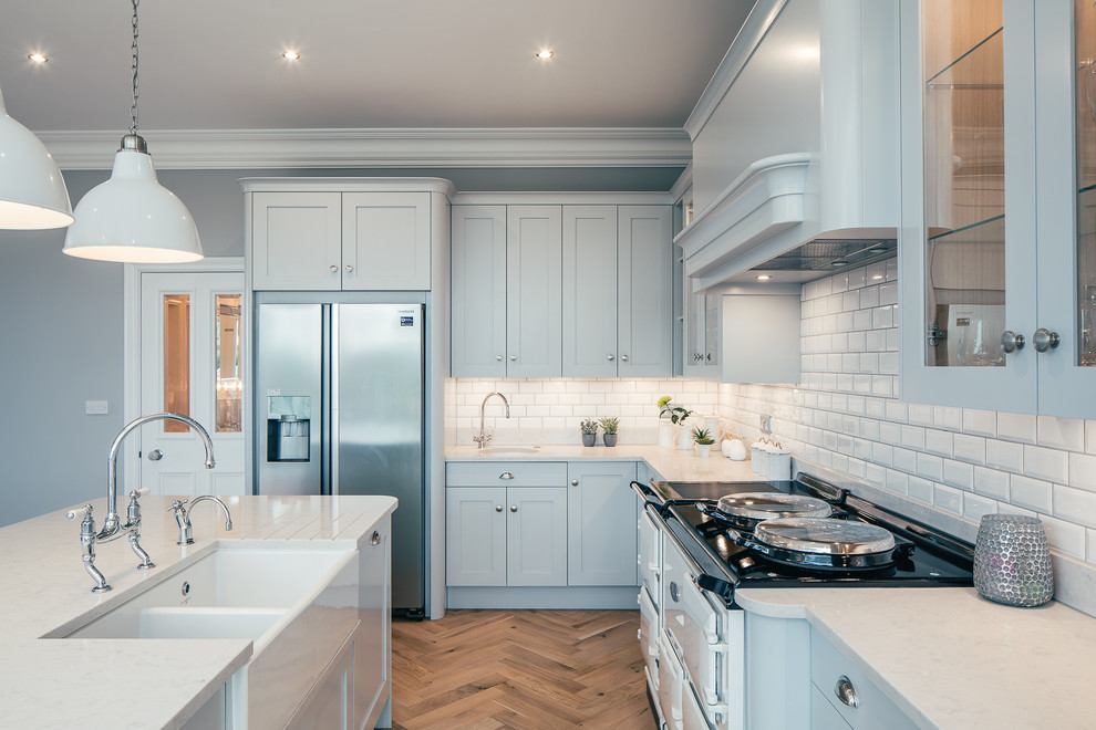 Photo of a large traditional kitchen in Hertfordshire with flat-panel cabinets, blue cabinets and an island.