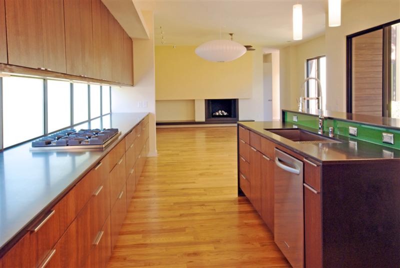 Exempel på ett stort modernt kök, med en undermonterad diskho, släta luckor, skåp i mellenmörkt trä, rostfria vitvaror, mellanmörkt trägolv, en köksö och brunt golv