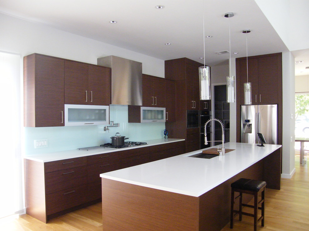 Idee per una grande cucina moderna con lavello sottopiano, ante lisce, ante in legno bruno, paraspruzzi blu, elettrodomestici in acciaio inossidabile, parquet chiaro e pavimento marrone