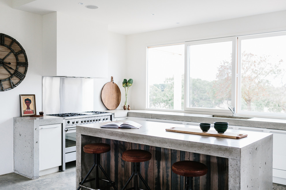 Moderne Küche mit integriertem Waschbecken, flächenbündigen Schrankfronten, weißen Schränken, Betonarbeitsplatte, Küchengeräten aus Edelstahl, Betonboden und Kücheninsel in Geelong