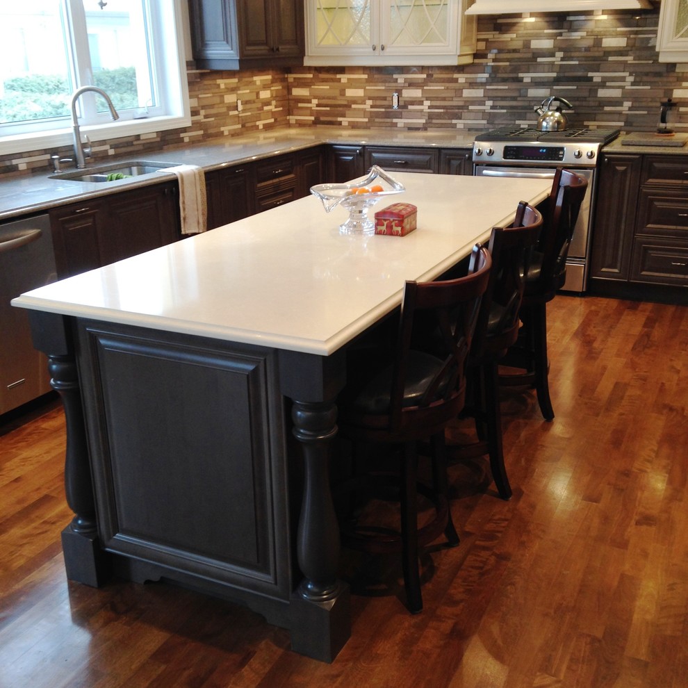 Inspiration for a large victorian u-shaped dark wood floor open concept kitchen remodel in Montreal with an undermount sink, raised-panel cabinets, brown cabinets, quartz countertops, multicolored backsplash and stainless steel appliances