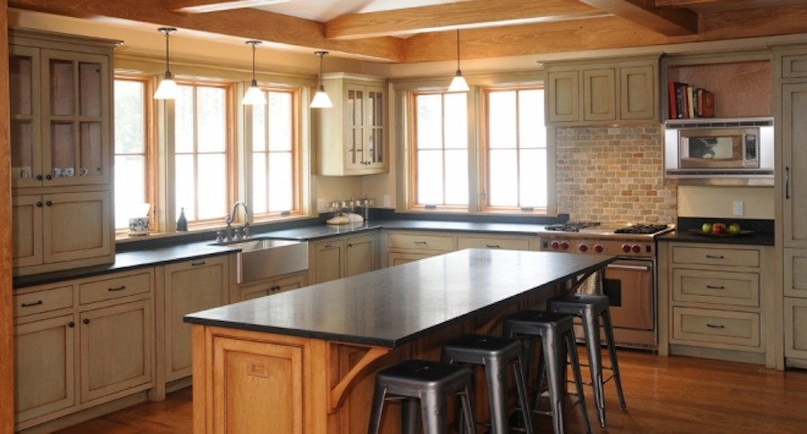 Bild på ett mellanstort rustikt kök, med rostfria vitvaror, en köksö, skåp i shakerstil, stänkskydd i tegel, mellanmörkt trägolv, en rustik diskho, skåp i slitet trä och bänkskiva i täljsten