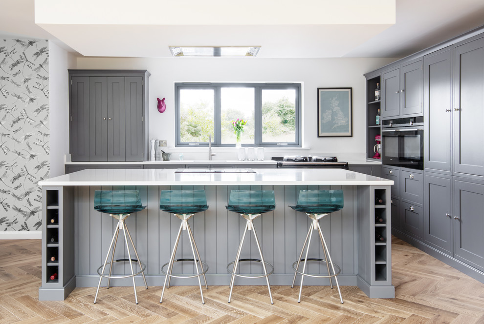 Design ideas for a large classic kitchen in Devon with shaker cabinets, grey cabinets, composite countertops, light hardwood flooring, an island, white worktops and beige floors.
