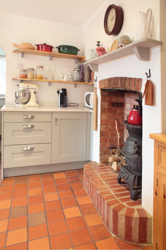 Exempel på ett mellanstort lantligt kök, med en undermonterad diskho, skåp i shakerstil, grå skåp, bänkskiva i kvartsit, grått stänkskydd, glaspanel som stänkskydd, rostfria vitvaror och klinkergolv i terrakotta