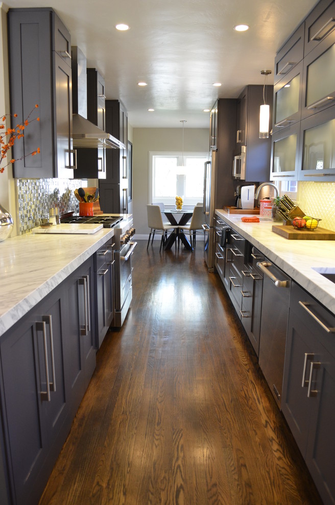 Example of a large trendy galley dark wood floor kitchen design in Sacramento with an undermount sink, shaker cabinets, gray cabinets, marble countertops, white backsplash, stainless steel appliances and no island