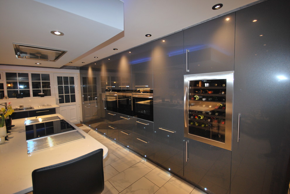 Photo of a modern kitchen in Other with flat-panel cabinets, grey cabinets, composite countertops and stainless steel appliances.