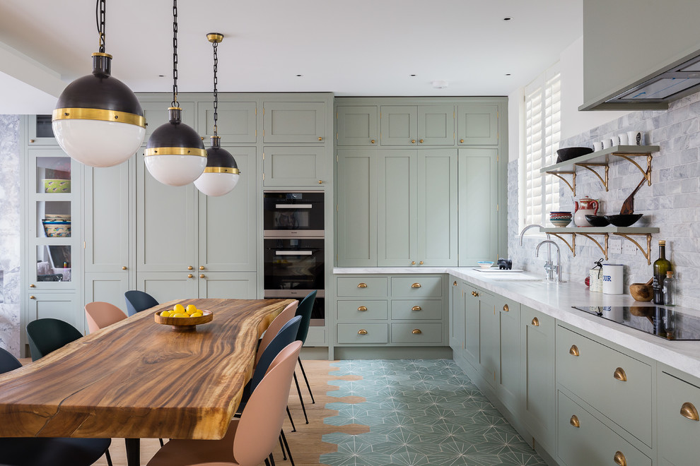 Photo of a medium sized eclectic l-shaped kitchen/diner in London with a submerged sink, recessed-panel cabinets, grey cabinets, grey splashback, stainless steel appliances, no island, beige floors and white worktops.