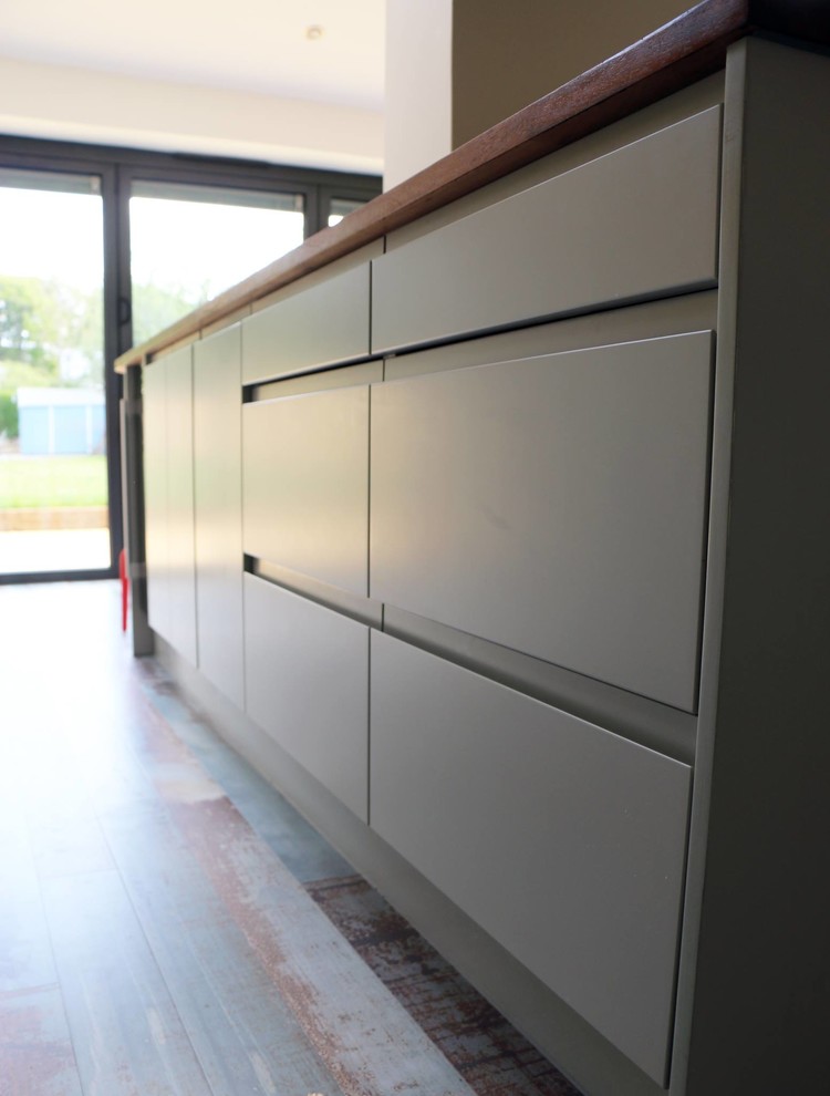 Design ideas for a modern kitchen/diner in Other with grey cabinets, wood worktops, yellow splashback and an island.