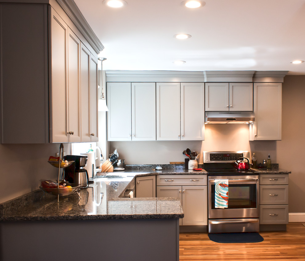 Small traditional u-shaped kitchen/diner in Boston with a submerged sink, shaker cabinets, grey cabinets, granite worktops, stainless steel appliances, light hardwood flooring and a breakfast bar.