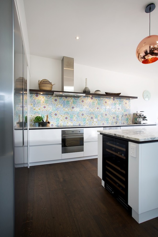 Inspiration for a large contemporary l-shaped open plan kitchen in Auckland with a single-bowl sink, white cabinets, marble worktops, multi-coloured splashback, ceramic splashback, stainless steel appliances, dark hardwood flooring and an island.