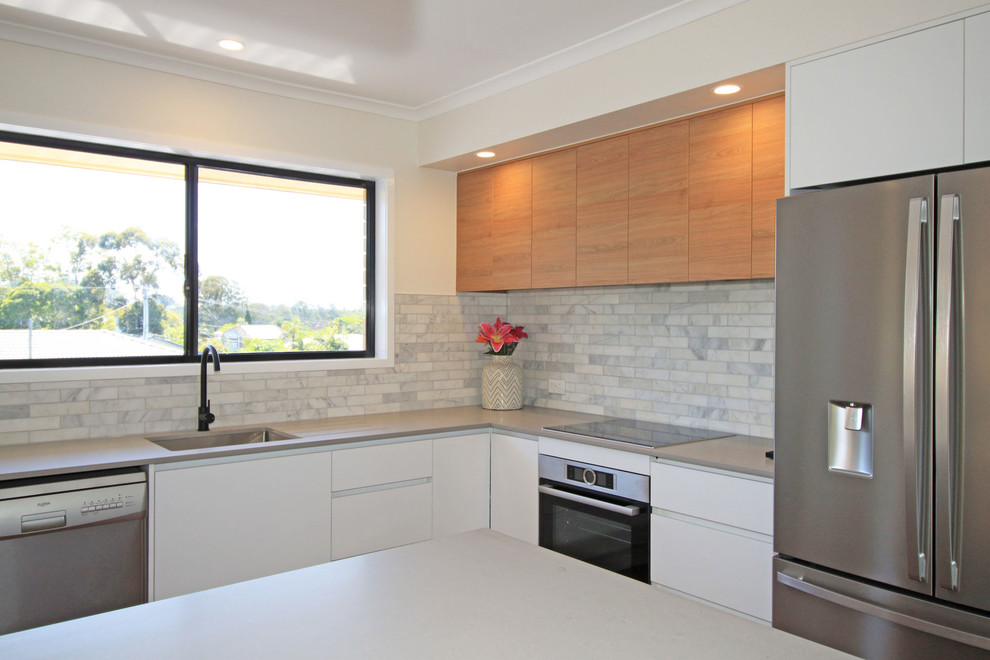 Inspiration for a medium sized modern l-shaped open plan kitchen in Brisbane with a submerged sink, flat-panel cabinets, white cabinets, engineered stone countertops, grey splashback, marble splashback, stainless steel appliances, dark hardwood flooring, an island, brown floors and grey worktops.