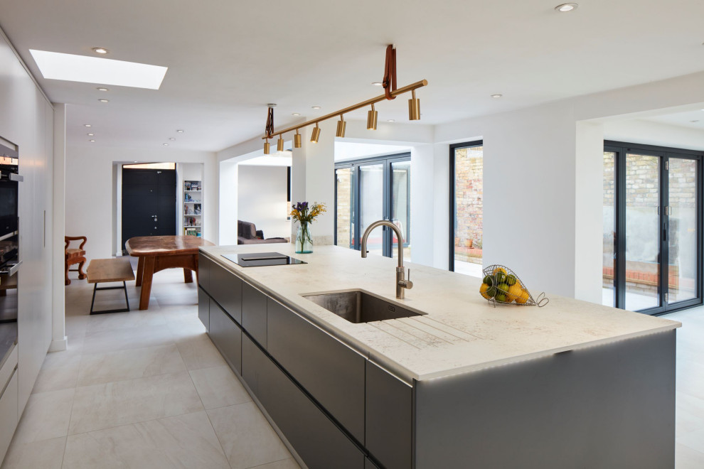 Immagine di una grande cucina minimal con ante con riquadro incassato, ante grigie, elettrodomestici in acciaio inossidabile, pavimento multicolore e top bianco
