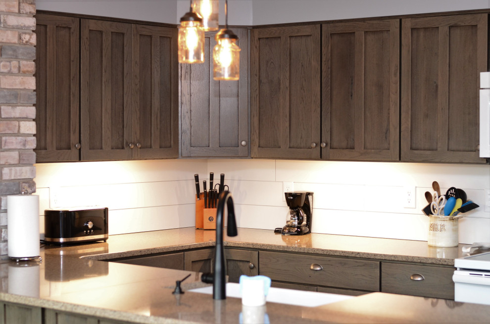 Exempel på ett mellanstort rustikt brun brunt kök, med en rustik diskho, luckor med infälld panel, grå skåp, bänkskiva i kvartsit, vitt stänkskydd, vita vitvaror, laminatgolv, en halv köksö och brunt golv
