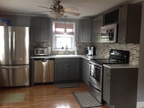 Gray RTA kitchen cabinets with stainless steel appliances, tile backsplash, and U-shaped modern layout