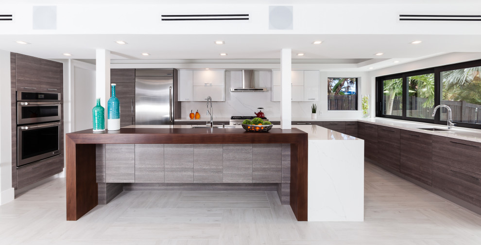 Esempio di una cucina contemporanea con lavello sottopiano, ante lisce, ante in legno bruno, paraspruzzi bianco, elettrodomestici in acciaio inossidabile, pavimento grigio e top bianco