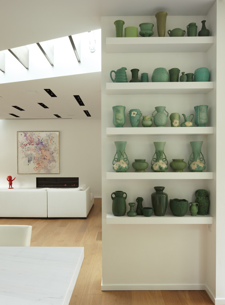 This is an example of a medium sized modern galley open plan kitchen in Los Angeles with a submerged sink, flat-panel cabinets, white cabinets, marble worktops, white splashback, glass sheet splashback, stainless steel appliances, medium hardwood flooring and an island.