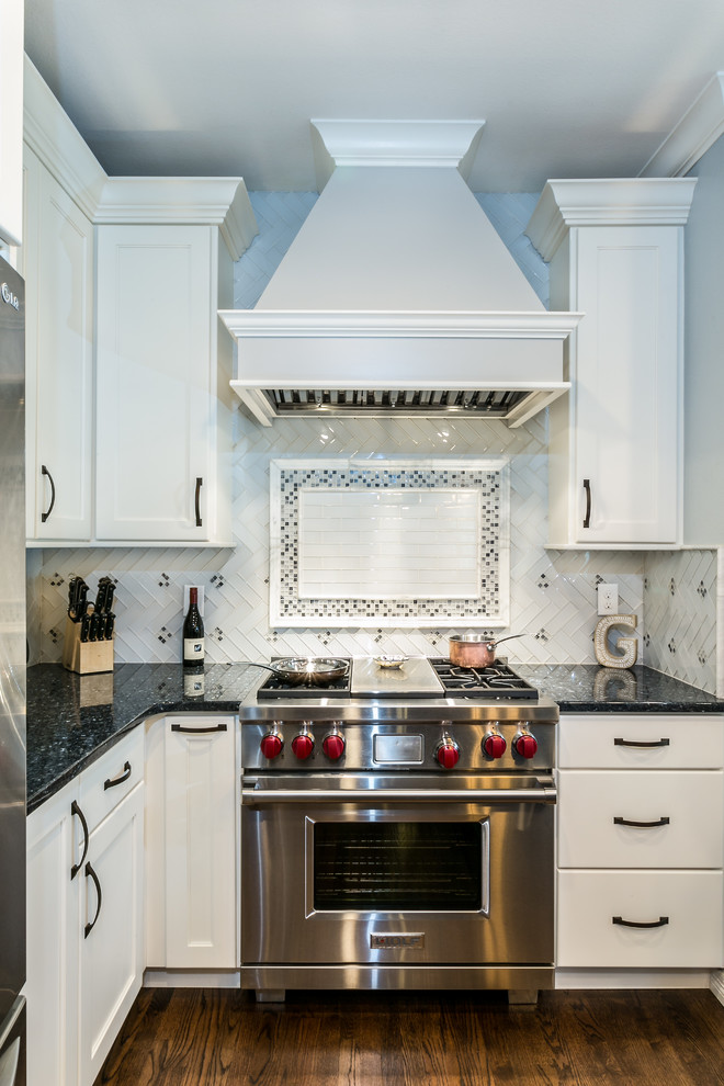 Esempio di una cucina tradizionale con ante in stile shaker, ante bianche, elettrodomestici in acciaio inossidabile e pavimento marrone