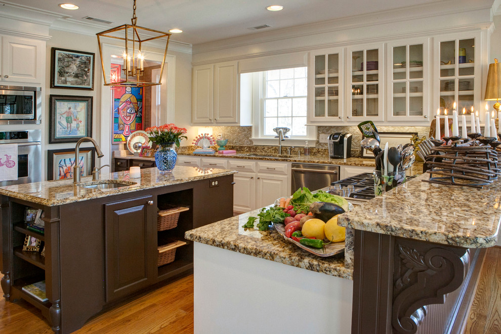 Eat-in kitchen - large eclectic u-shaped medium tone wood floor eat-in kitchen idea in Other with raised-panel cabinets, white cabinets, an island, an undermount sink, granite countertops, beige backsplash, glass tile backsplash and stainless steel appliances