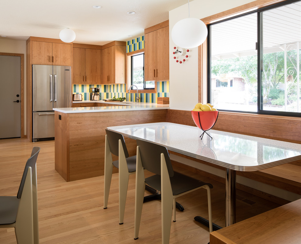 Inspiration for a large 1960s u-shaped light wood floor eat-in kitchen remodel in Portland with an undermount sink, flat-panel cabinets, medium tone wood cabinets, multicolored backsplash, ceramic backsplash, stainless steel appliances, a peninsula and white countertops