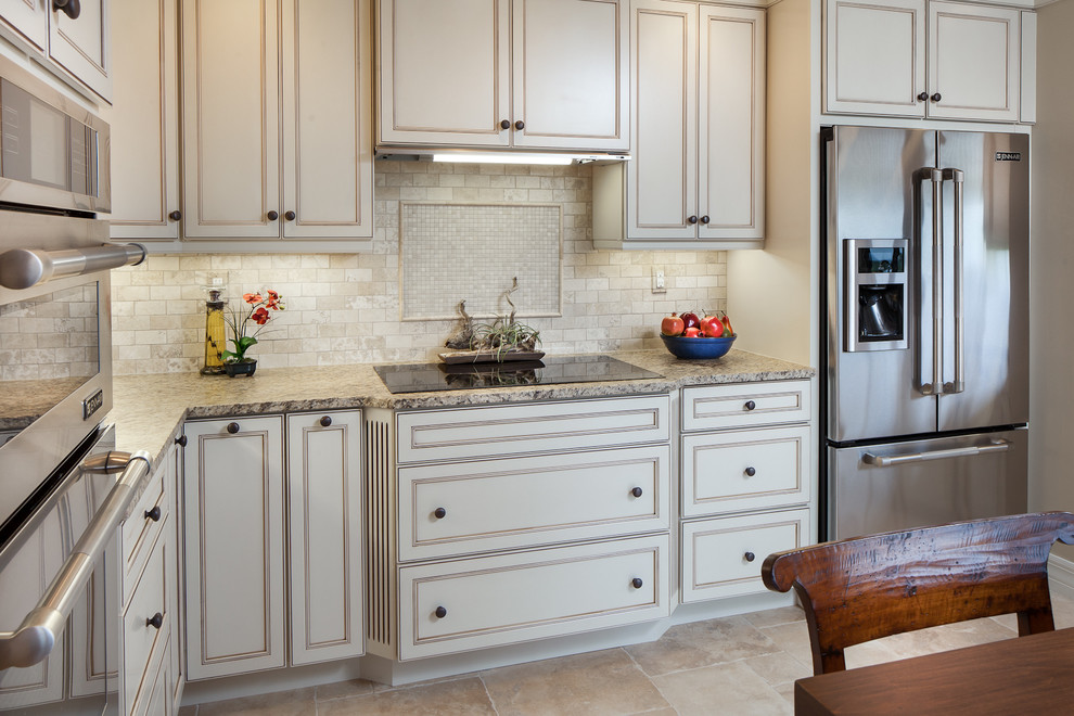 Example of a mid-sized classic u-shaped ceramic tile eat-in kitchen design in Miami with recessed-panel cabinets, distressed cabinets, granite countertops, multicolored backsplash, stone slab backsplash, stainless steel appliances, an undermount sink and no island
