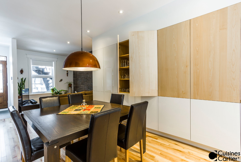Photo of a large scandi open plan dining room in Montreal with light hardwood flooring.