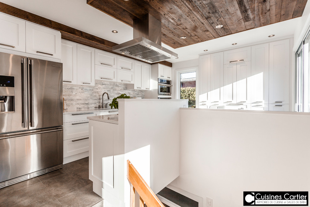 Exempel på ett stort modernt kök med öppen planlösning, med en dubbel diskho, skåp i shakerstil, vita skåp, bänkskiva i kvartsit, vitt stänkskydd, stänkskydd i stenkakel, rostfria vitvaror, betonggolv och en köksö
