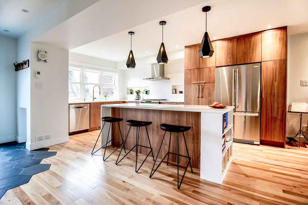 Exempel på ett mellanstort modernt kök, med en undermonterad diskho, släta luckor, skåp i mörkt trä, bänkskiva i kvartsit, vitt stänkskydd, stänkskydd i keramik, rostfria vitvaror, ljust trägolv, en köksö och flerfärgat golv