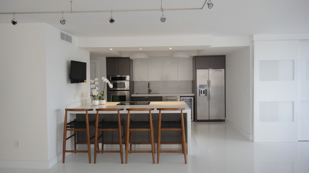Свежая идея для дизайна: параллельная кухня-гостиная в современном стиле с плоскими фасадами, белыми фасадами, белым фартуком и фартуком из стекла - отличное фото интерьера