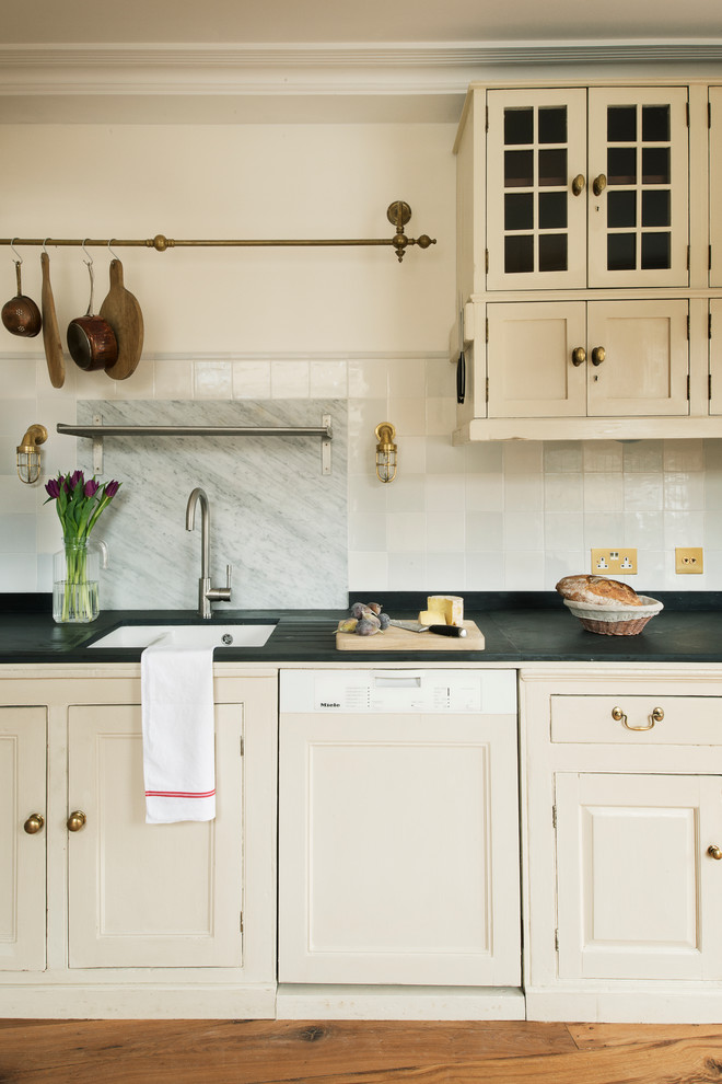 Traditional grey and cream galley open plan kitchen in London with beaded cabinets, white cabinets, ceramic splashback, stainless steel appliances and no island.