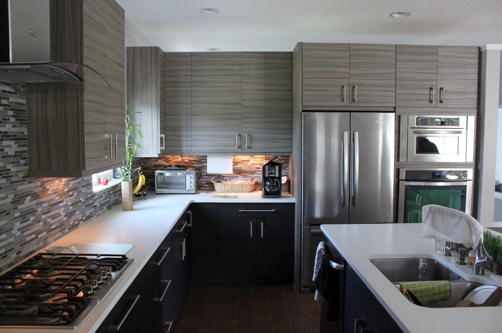 Idéer för mellanstora funkis kök, med en dubbel diskho, släta luckor, grå skåp, bänkskiva i kvartsit, grått stänkskydd, stänkskydd i stickkakel, rostfria vitvaror, mellanmörkt trägolv, en köksö och brunt golv