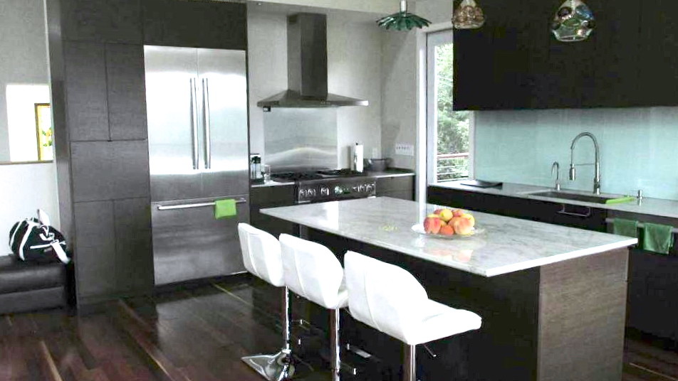 Bild på ett mellanstort funkis kök, med en undermonterad diskho, släta luckor, skåp i mörkt trä, marmorbänkskiva, glaspanel som stänkskydd, rostfria vitvaror, mörkt trägolv och en köksö