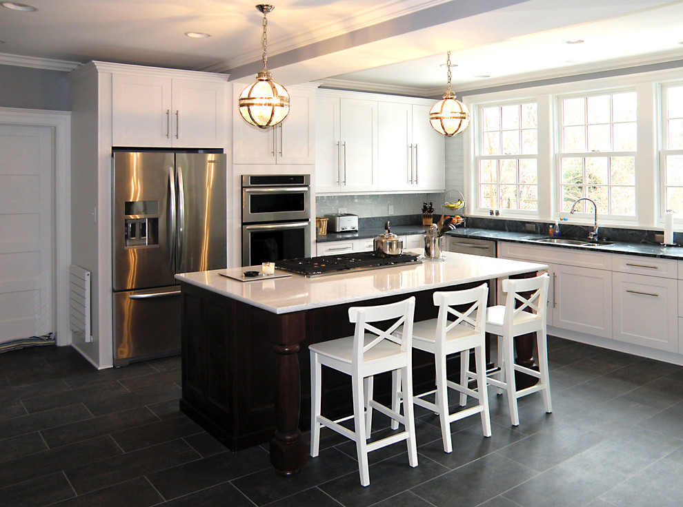 Example of a large transitional l-shaped ceramic tile enclosed kitchen design in Baltimore with an undermount sink, shaker cabinets, white cabinets, soapstone countertops, green backsplash, glass tile backsplash, stainless steel appliances and an island