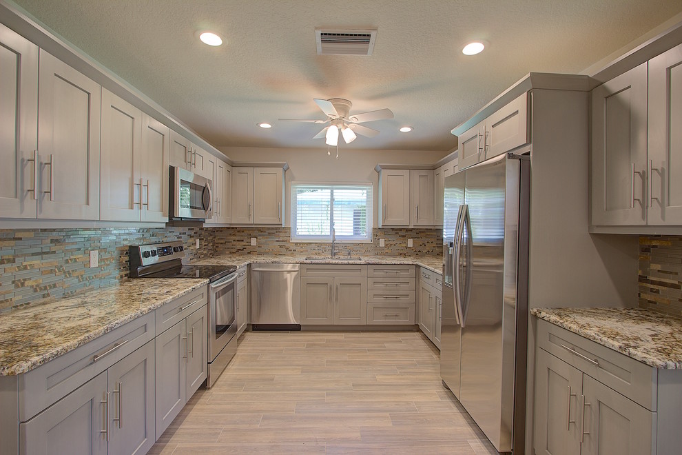This is an example of a medium sized classic kitchen in Tampa with a submerged sink, shaker cabinets, grey cabinets, multi-coloured splashback, glass tiled splashback, stainless steel appliances, ceramic flooring and no island.